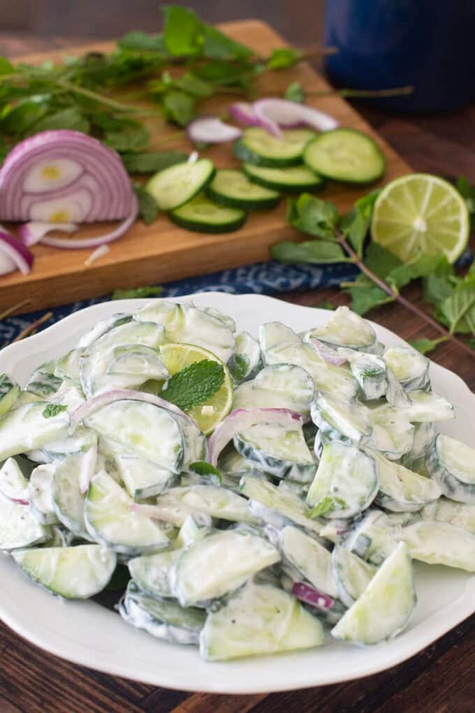 Cucumber Mint Salad with creamy dressing on a white plate.