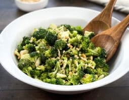 White bowl of Asian broccoli salad with cashews.