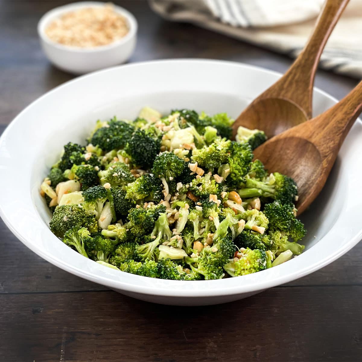White bowl of Asian broccoli salad with cashews.