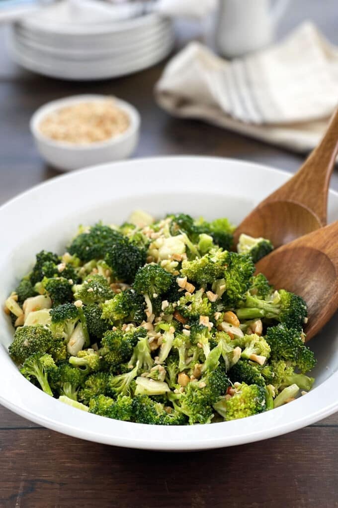 White bowl of Asian broccoli salad with cashews.