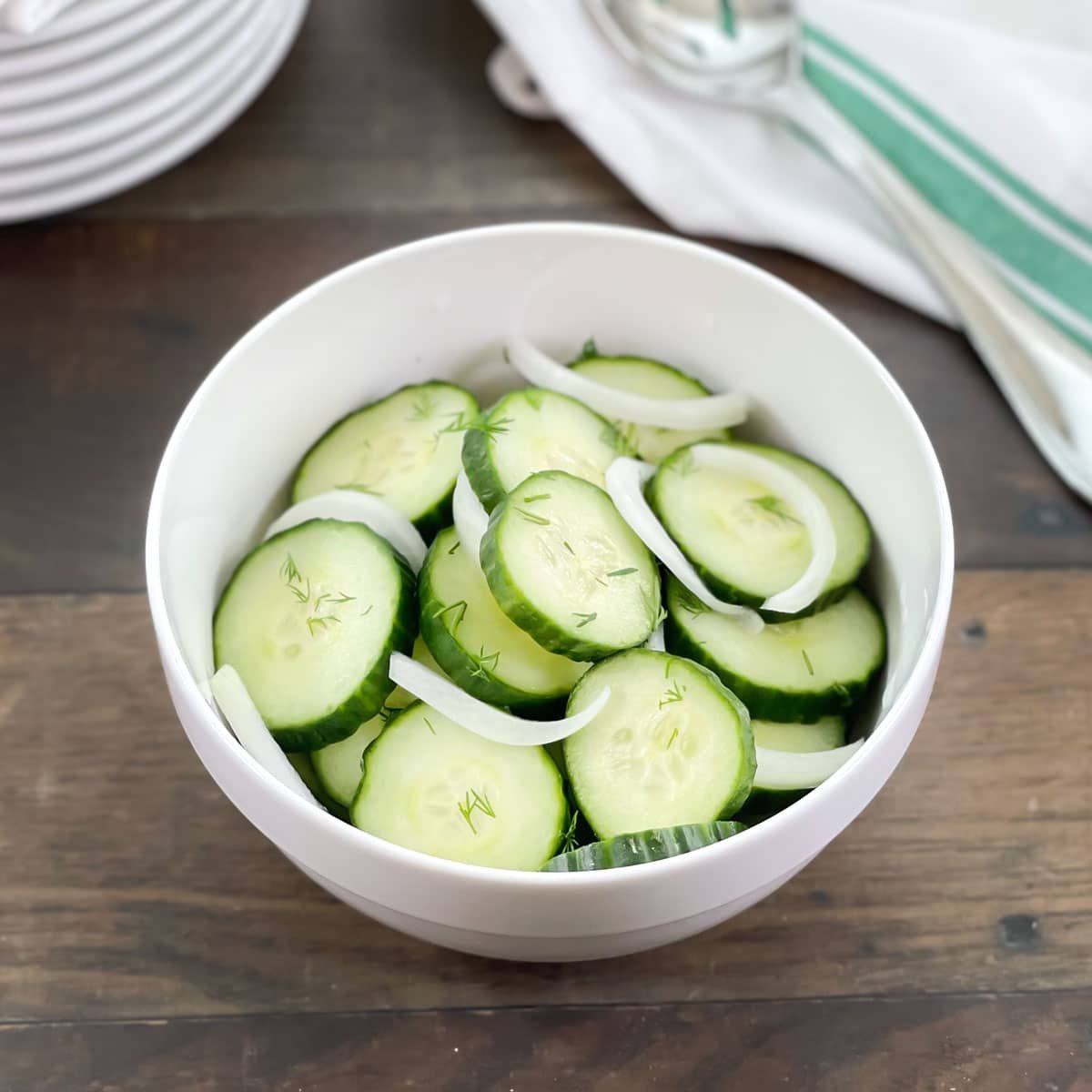 White bowl of cucumber onion salad.