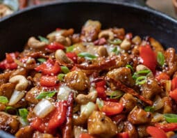 Cast iron pan with szechuan chicken with peppers and chilis.