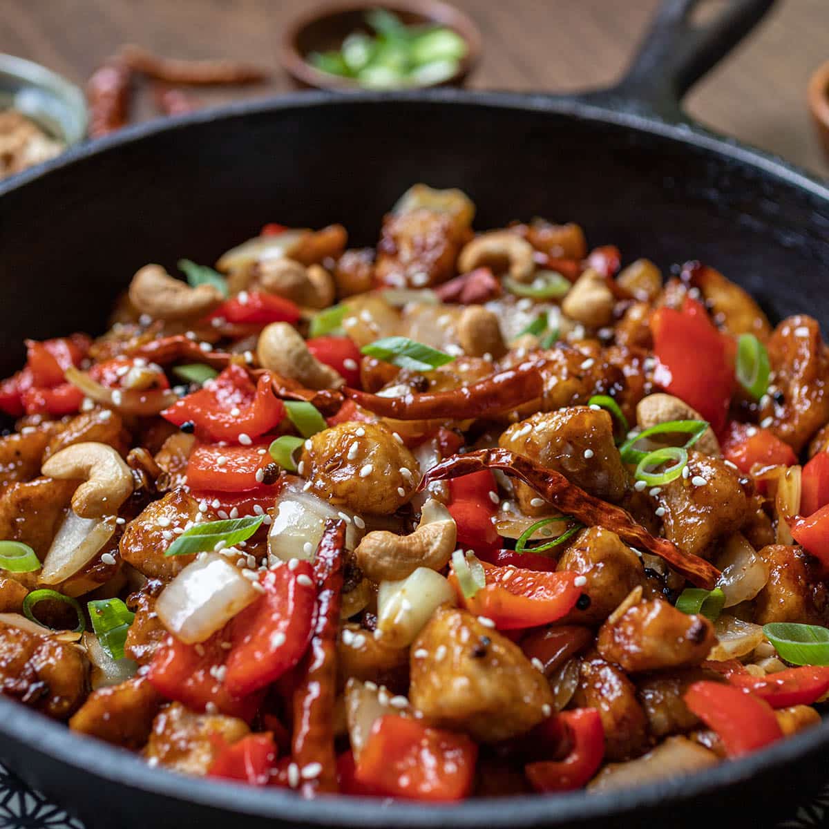 Cast iron pan with szechuan chicken with peppers and chilis.