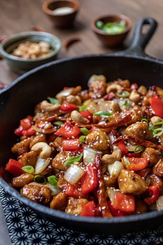 Cast iron pan with szechuan chicken with peppers and chilis.