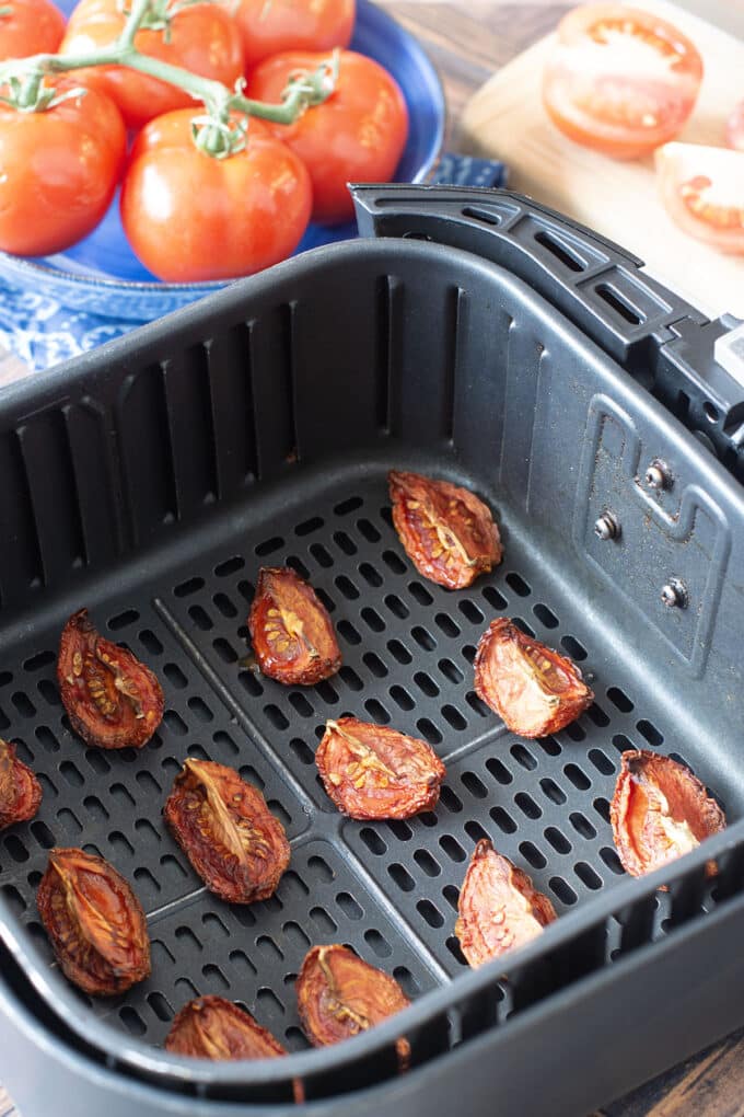 Dried tomato wedges in the air fryer basket.