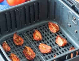 Dried tomato wedges in the air fryer basket.