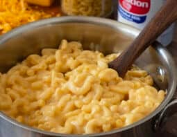 Macaroni and cheese in a pot with wooden spoon.