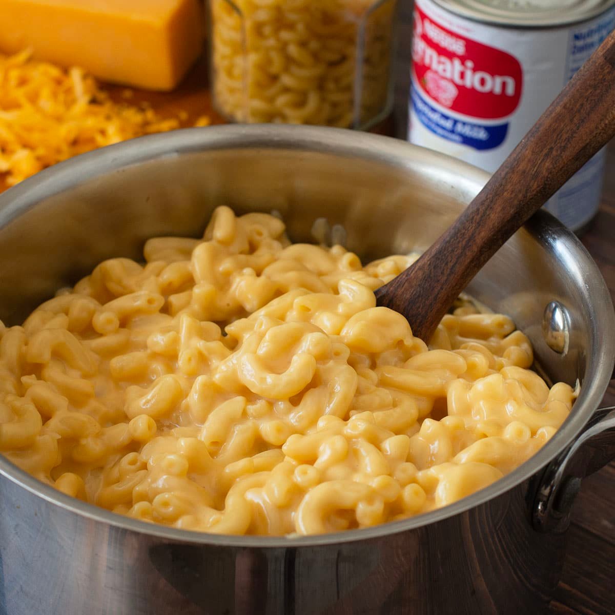 Macaroni and cheese in a pot with wooden spoon.