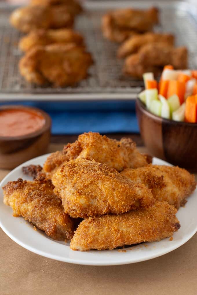 Breaded boneless chicken wings on a white plate.