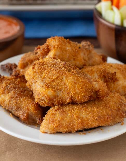 Breaded boneless chicken wings on a white plate.