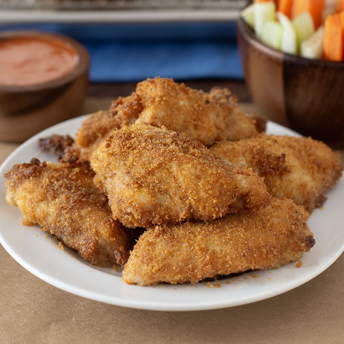 Breaded boneless chicken wings on a white plate.