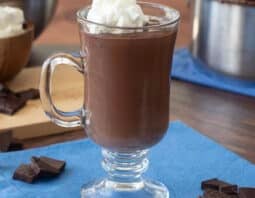Glass mug of French hot chocolate topped with whipped cream.