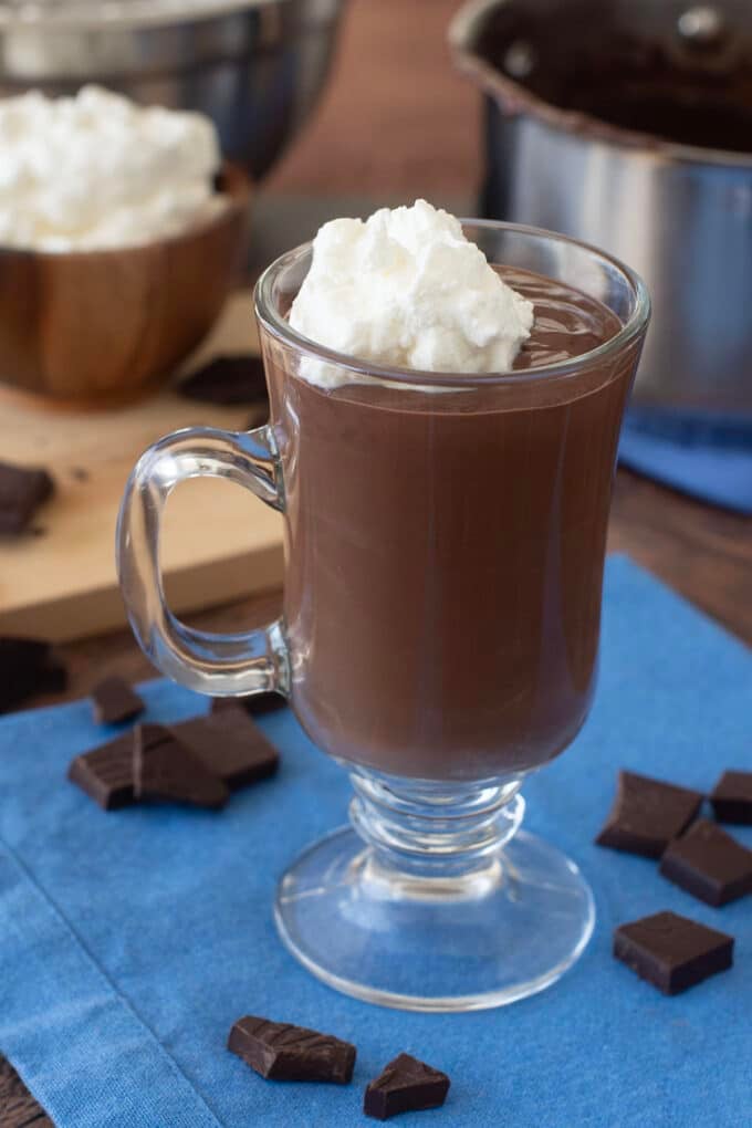 Glass mug of French hot chocolate topped with whipped cream.