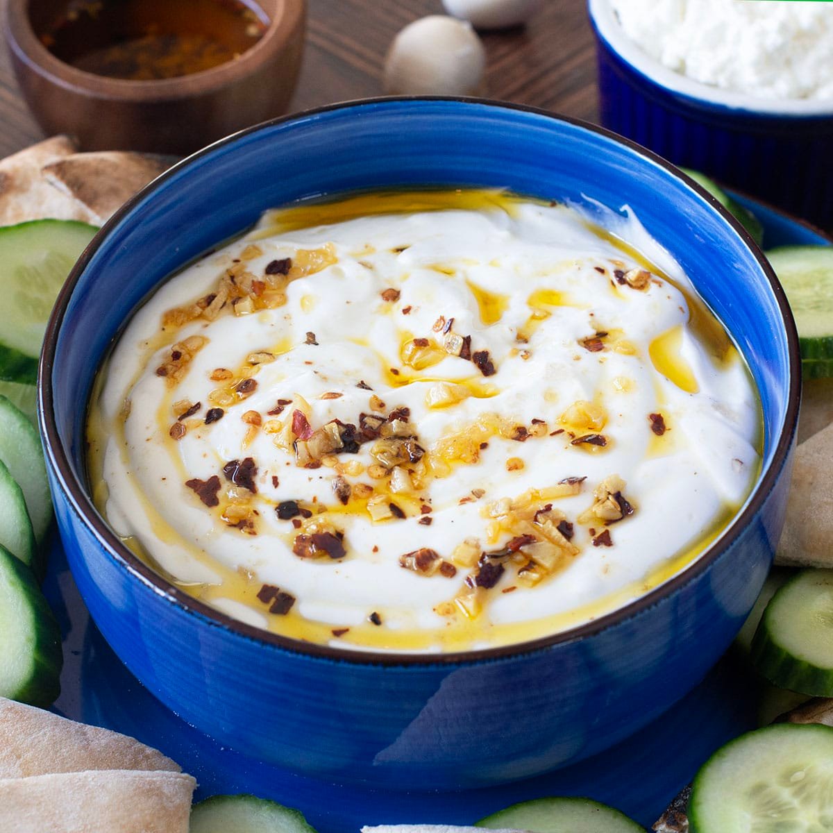 Blue bowl of whipped cottage cheese topped with chili garlic oil.