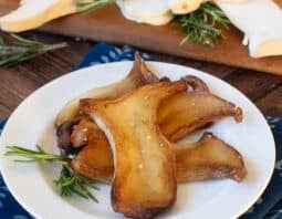 White plate with pan fried king oyster mushroom slices.