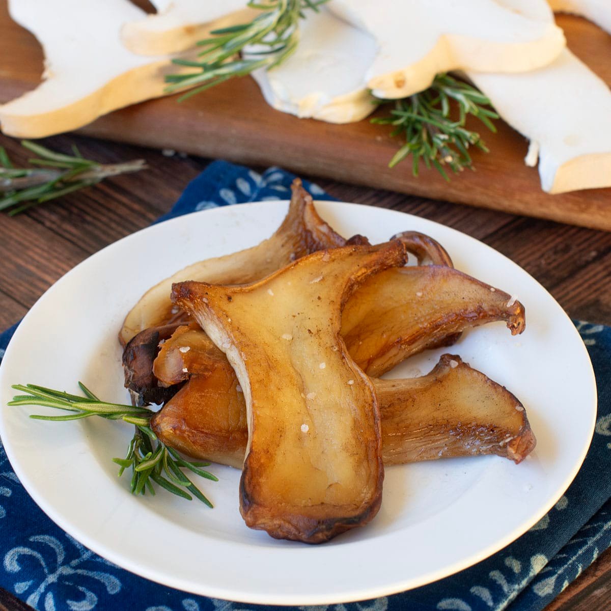 White plate with pan fried king oyster mushroom slices.