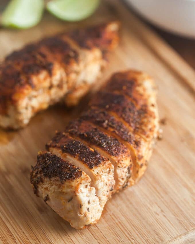 Sliced blackened chicken breasts on cutting board.