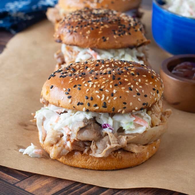 sandwiches with BBQ pulled chicken and coleslaw on a sesame seed bun.