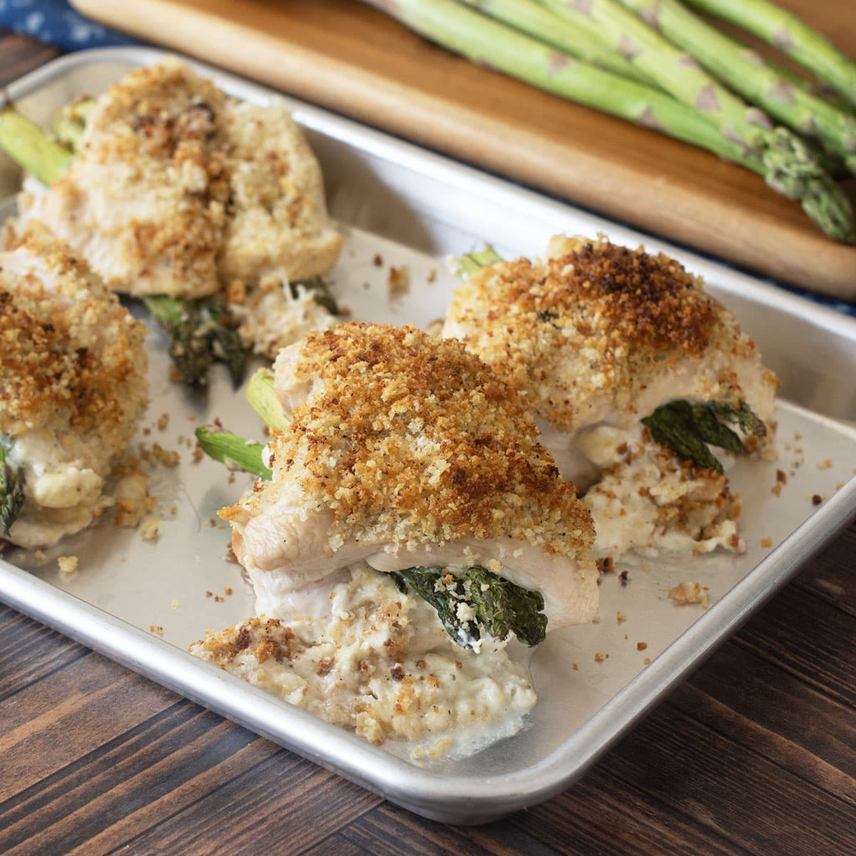 Whit platter with 4 asparagus stuffed chicken breasts with breadcrumb topping.