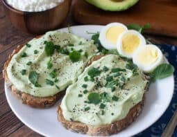 Whipped avocado cottage cheese on toast with hard boiled egg beside.