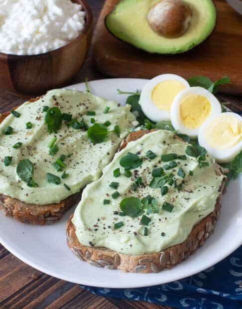 Whipped avocado cottage cheese on toast with hard boiled egg beside.