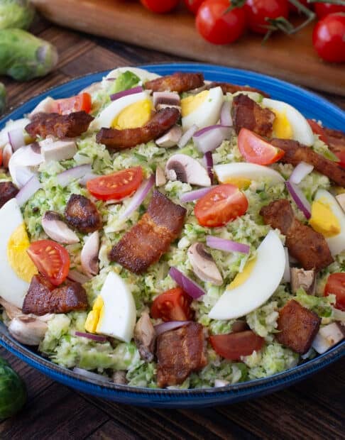 Shredded Brussels sprouts with bacon, hard boiled eggs, and tomatoes.