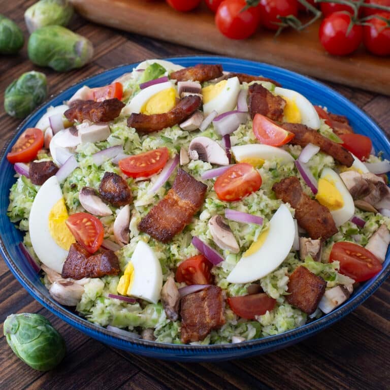 Shredded Brussels sprouts with bacon, hard boiled eggs, and tomatoes.