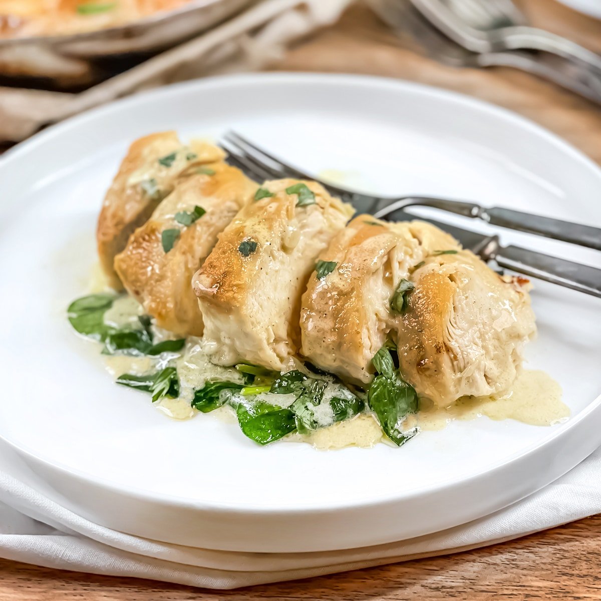 Sliced chicken florentine on a white plate.