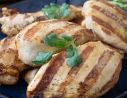Marinated and grilled chicken breasts on plate.