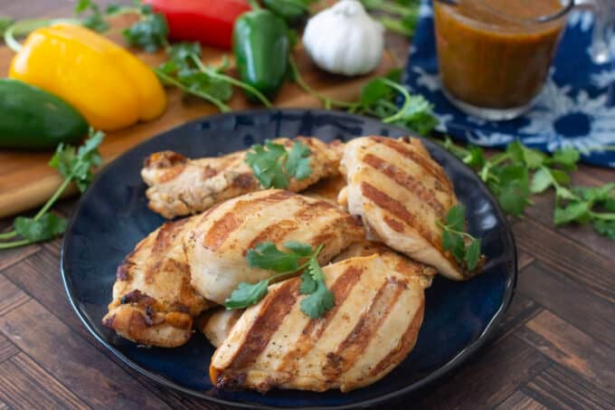 Marinated and grilled chicken breasts on plate.