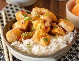 Bowl of white rice and orange chicken.
