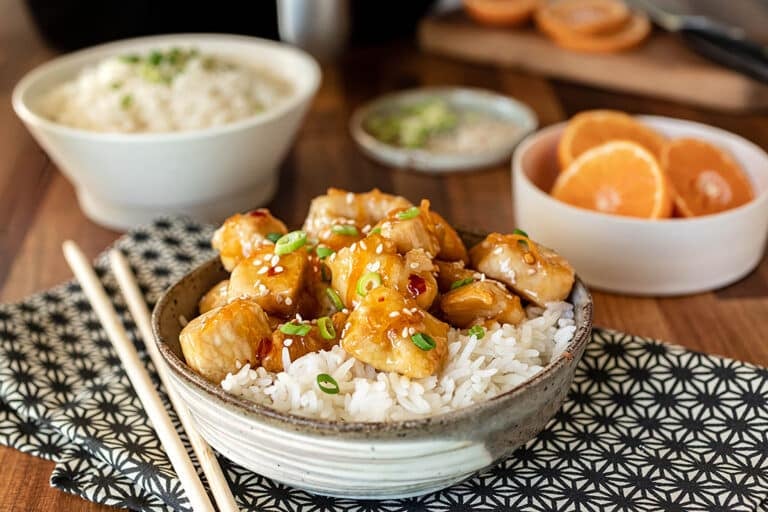 Bowl of white rice and orange chicken.