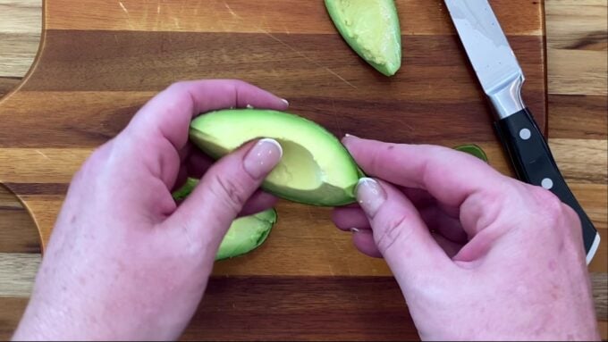 Peeling a wedge of avocado