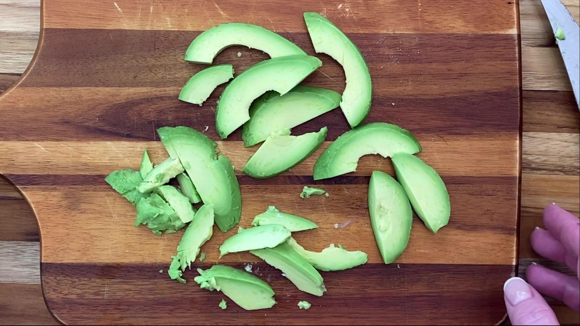 Sliced avocado on cutting board.