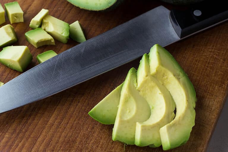 Avocado slices and cubes with knife.