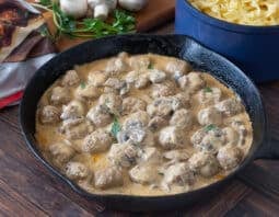 Pan of meatballs in creamy mushroom sauce.