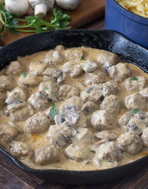 Pan of meatballs in creamy mushroom sauce.