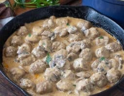 Pan of meatballs in creamy mushroom sauce.