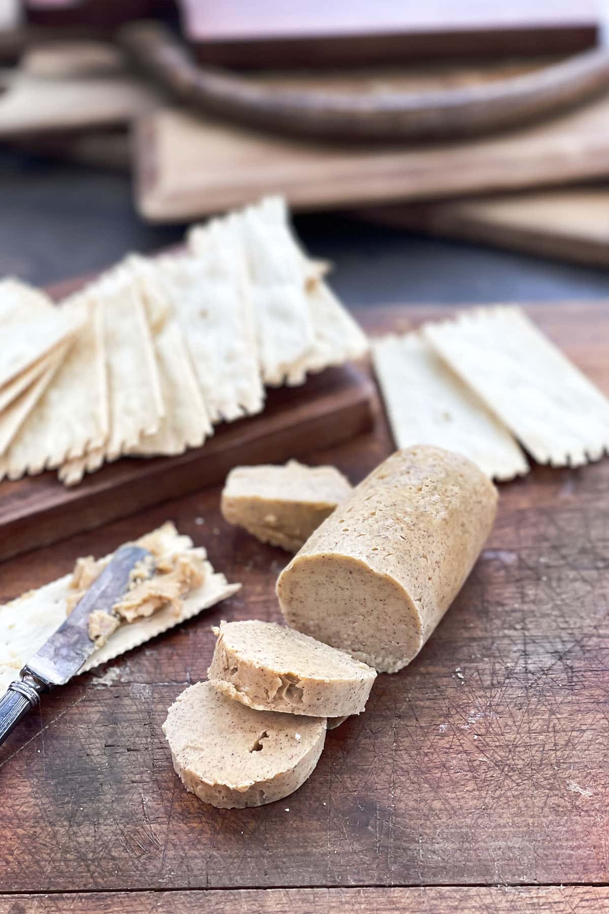 Log of pumpkin spice butter with slices cut and crackers.