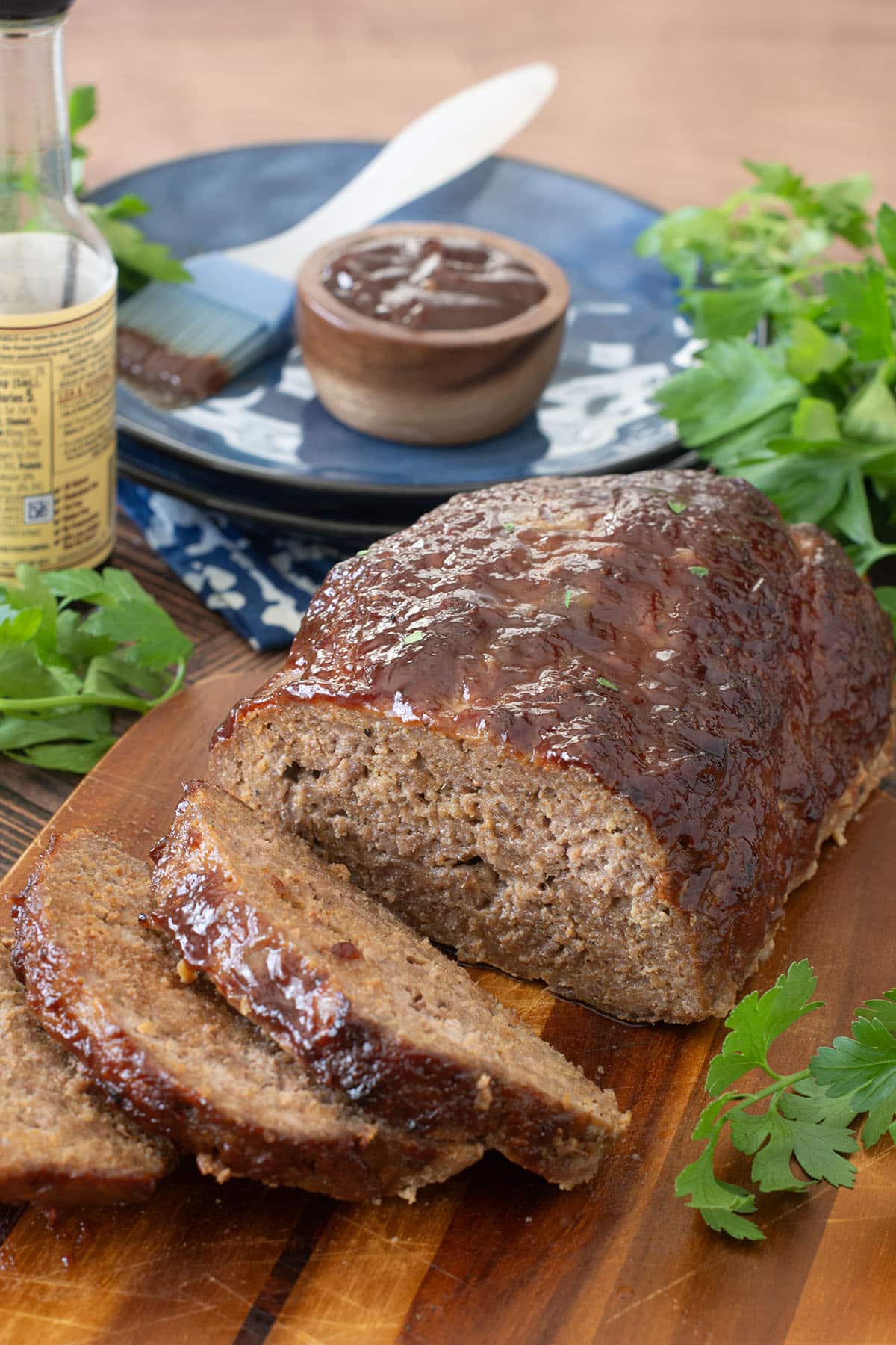 Meatloaf topped with bbq sauce with several slices cut.