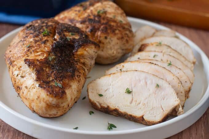 Turkey tenderloins, one sliced, on a plate.